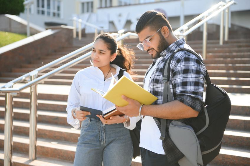 Law school students standing outside of a building, holding books