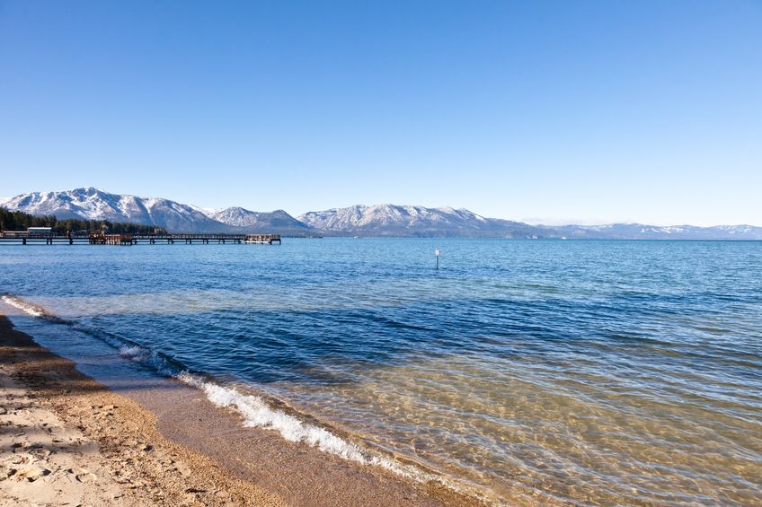 A shoreline view of Lake Tahoe with the Sierra Nevada Mountains in the background